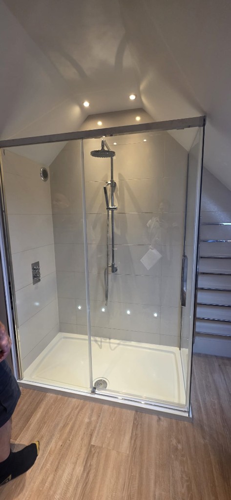Loft bathroom walk-in shower with rainfall head and chrome fittings by Ikveles Construction