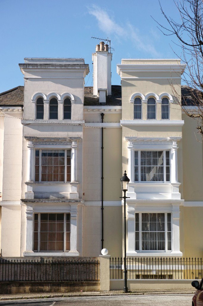 House facade before and after external rendering with cream finish and white trim by Ikveles Construction