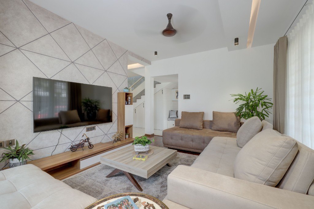Finished modern living room with feature wall, sectional sofa and wood flooring by Ikveles Construction