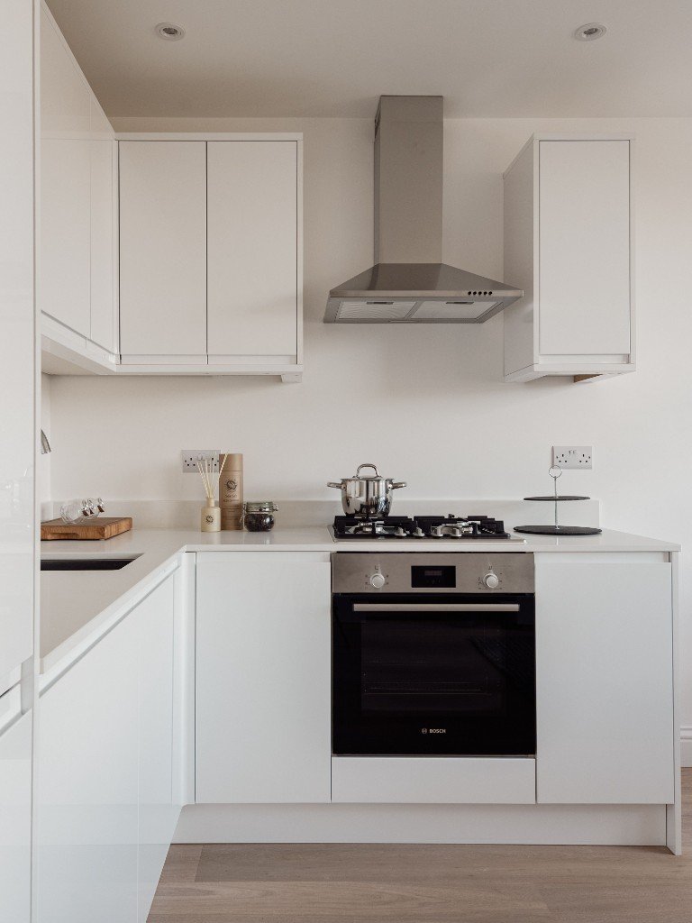 Modern white kitchen installation with Bosch oven, gas hob and chimney hood by Ikveles Construction