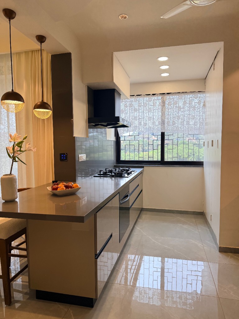 Modern kitchen refurbishment with grey peninsula, black range hood and garden view - kitchen installation by Ikveles Construction in the UK