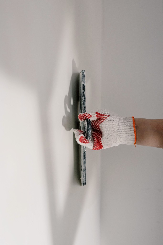 Professional plastering with a trowel on a smooth wall by Ikveles Construction