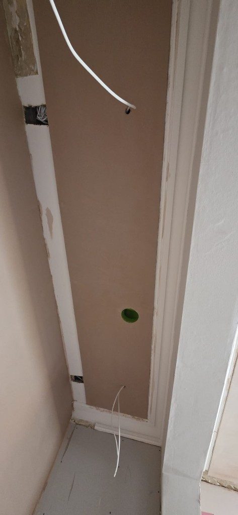 Smooth plastered wall section with electrical boxes and molding by Ikveles Construction